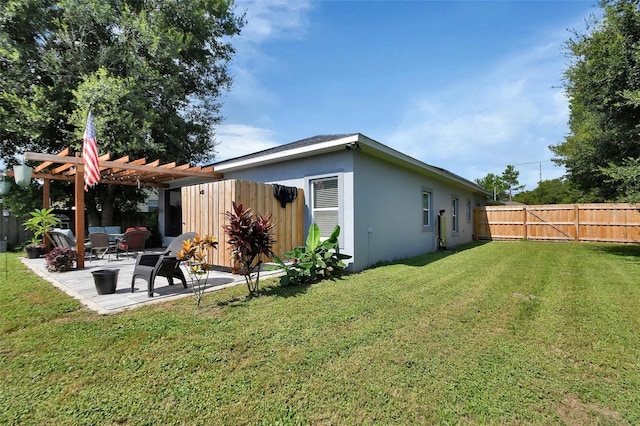 rear view of property featuring a pergola, a patio area, and a yard