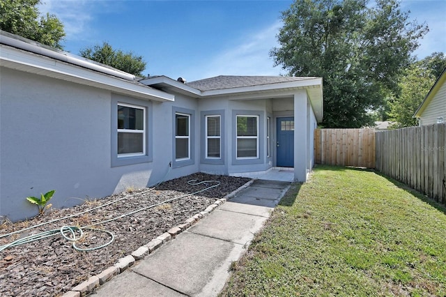 doorway to property featuring a lawn