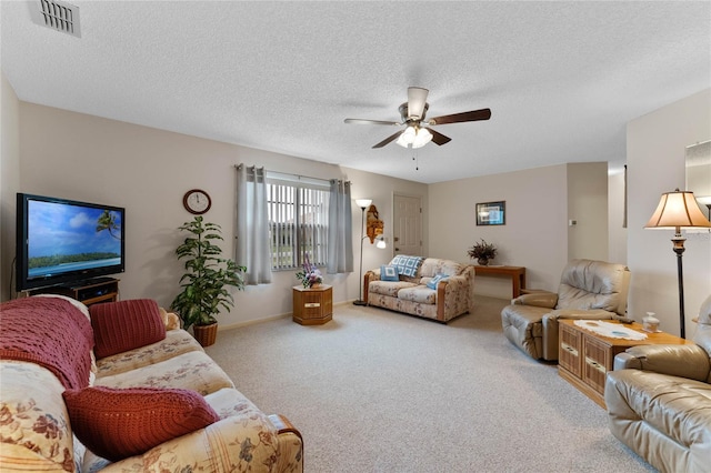 carpeted living room featuring ceiling fan and a textured ceiling