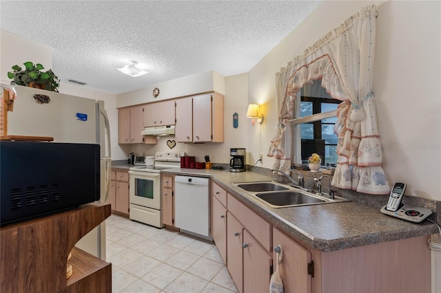 kitchen with sink, light tile patterned floors, a textured ceiling, and white appliances