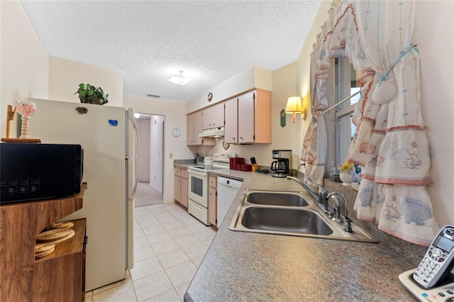 kitchen featuring light tile patterned flooring, sink, a textured ceiling, and white appliances