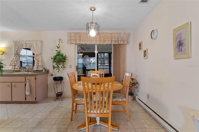 tiled dining area featuring a baseboard radiator and a textured ceiling