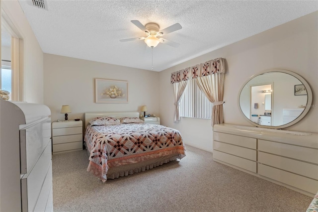 carpeted bedroom with ceiling fan and a textured ceiling