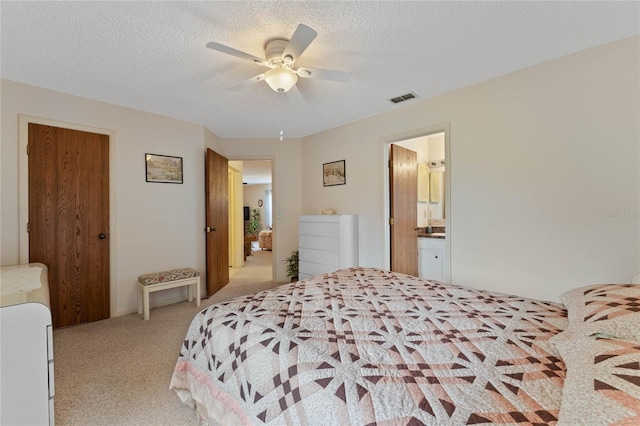 carpeted bedroom with ceiling fan and a textured ceiling