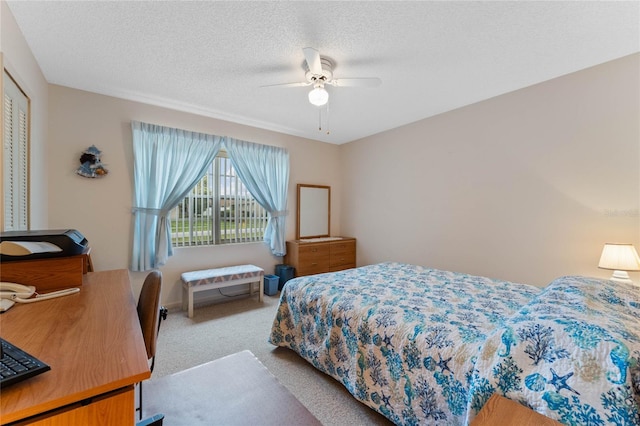 carpeted bedroom with ceiling fan and a textured ceiling