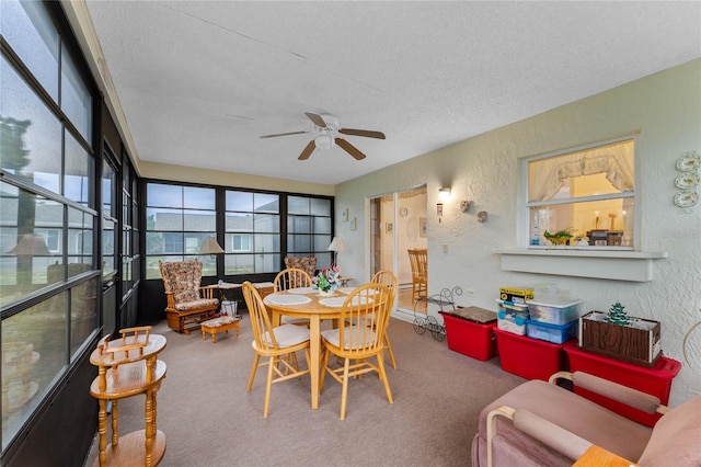 carpeted dining space featuring ceiling fan and a textured ceiling