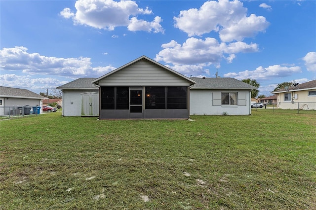 rear view of house featuring a yard and a sunroom