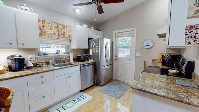 kitchen with sink, a healthy amount of sunlight, stainless steel appliances, vaulted ceiling, and white cabinets