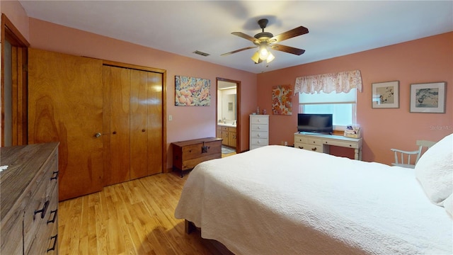 bedroom featuring ceiling fan, a closet, ensuite bathroom, and light wood-type flooring