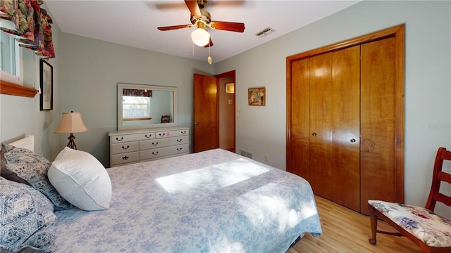 bedroom featuring a closet, light hardwood / wood-style floors, and ceiling fan