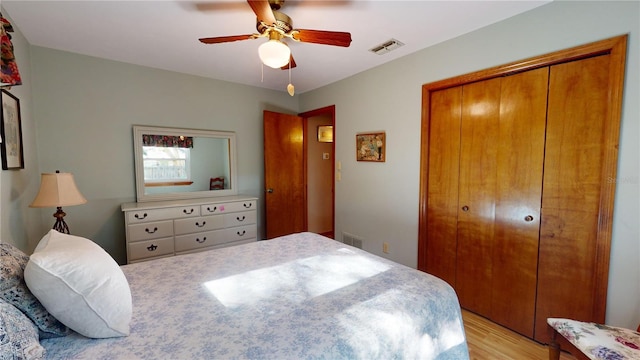 bedroom with a closet, light hardwood / wood-style flooring, and ceiling fan