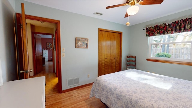 bedroom with ceiling fan, light hardwood / wood-style flooring, and a closet