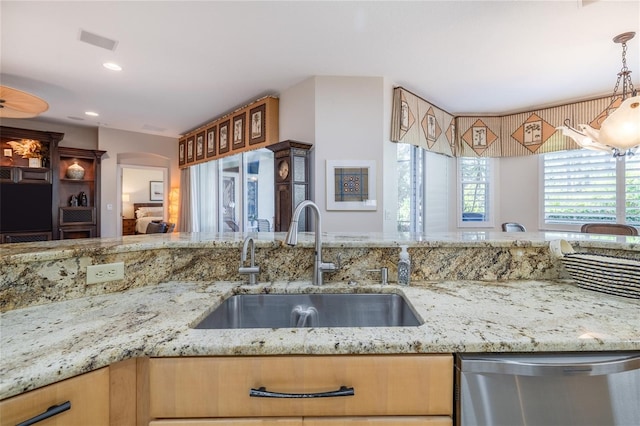 kitchen featuring light stone countertops, sink, hanging light fixtures, and dishwasher