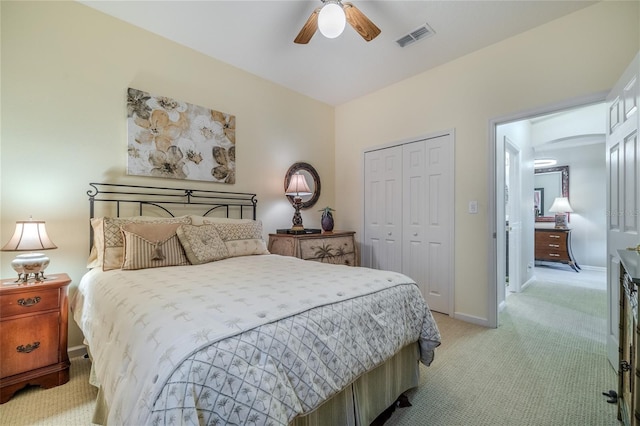 bedroom with ceiling fan, light colored carpet, and a closet