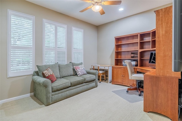 carpeted office space featuring ceiling fan