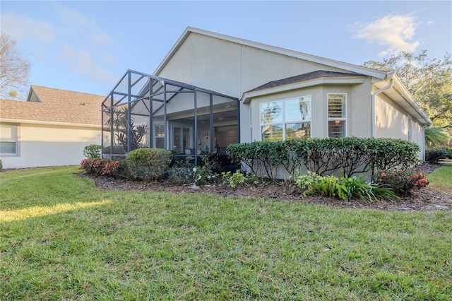 rear view of house with a lanai and a yard