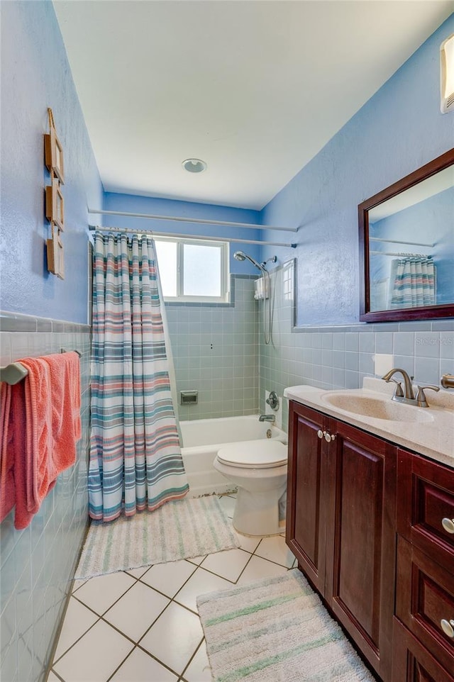 full bathroom with vanity, shower / tub combo with curtain, tile walls, tile patterned flooring, and toilet