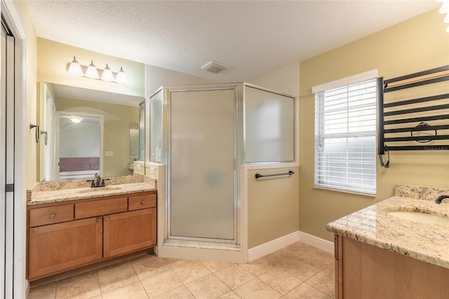 bathroom featuring a textured ceiling, a shower with door, tile patterned floors, and vanity