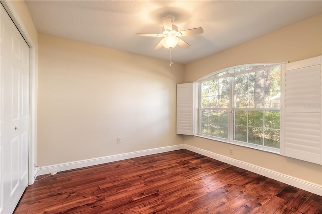 unfurnished room with ceiling fan and dark wood-type flooring