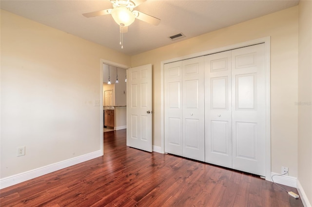 unfurnished bedroom with dark wood-type flooring, ceiling fan, and a closet