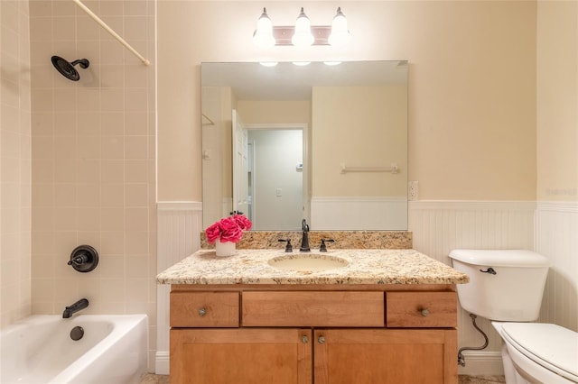 full bathroom with tiled shower / bath, vanity, and toilet