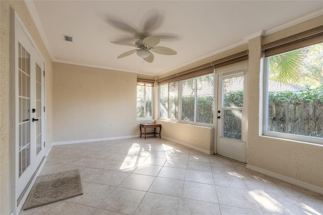 unfurnished sunroom featuring ceiling fan and french doors