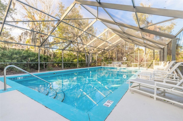 view of swimming pool featuring a patio area and glass enclosure