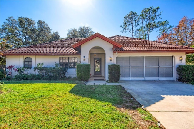 mediterranean / spanish-style home featuring a front yard and a garage