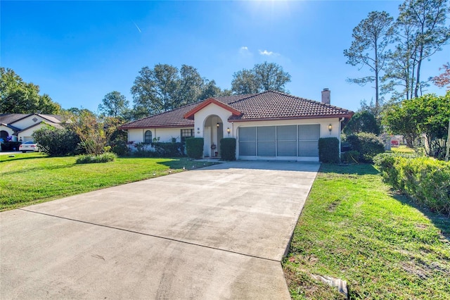 mediterranean / spanish home featuring a garage and a front lawn