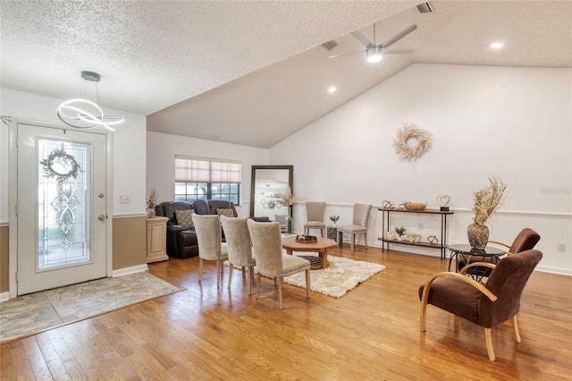 foyer featuring a textured ceiling, vaulted ceiling, light hardwood / wood-style flooring, and ceiling fan