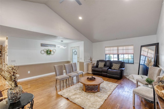 living room featuring ceiling fan, light hardwood / wood-style floors, and lofted ceiling