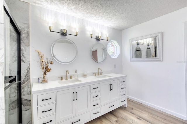 bathroom with hardwood / wood-style flooring, vanity, and a textured ceiling