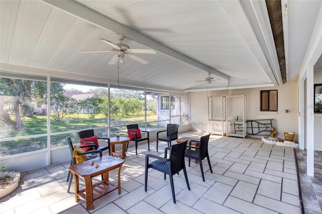 sunroom with lofted ceiling with beams and ceiling fan