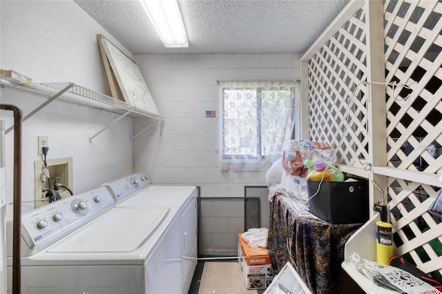 laundry room featuring a textured ceiling and washing machine and clothes dryer