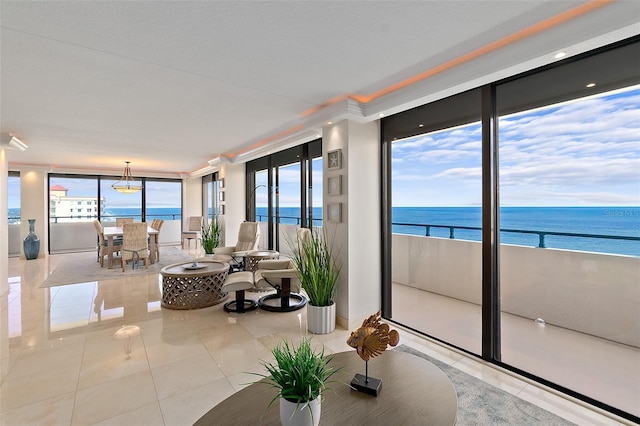 living room featuring light tile patterned floors, a water view, a wealth of natural light, and ornamental molding