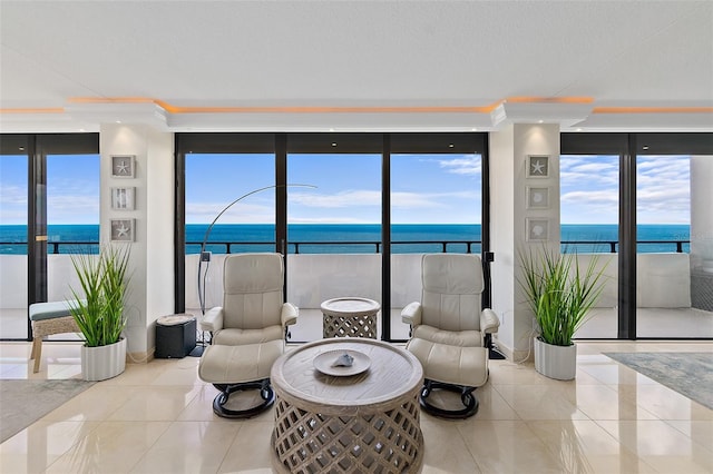 living room with expansive windows, crown molding, a water view, and light tile patterned floors