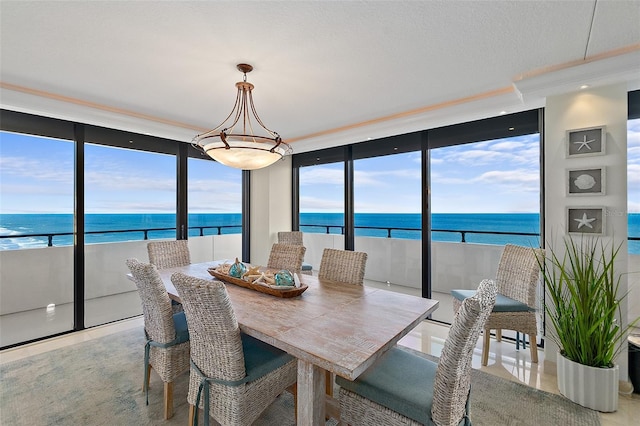 tiled dining area with expansive windows, a water view, a wealth of natural light, and crown molding