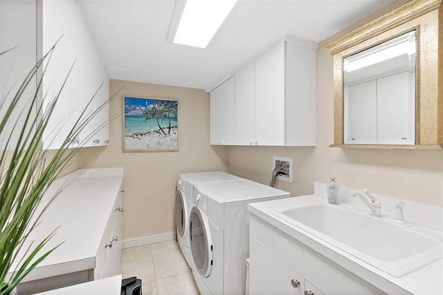 laundry area with washing machine and dryer, sink, light tile patterned flooring, and cabinets