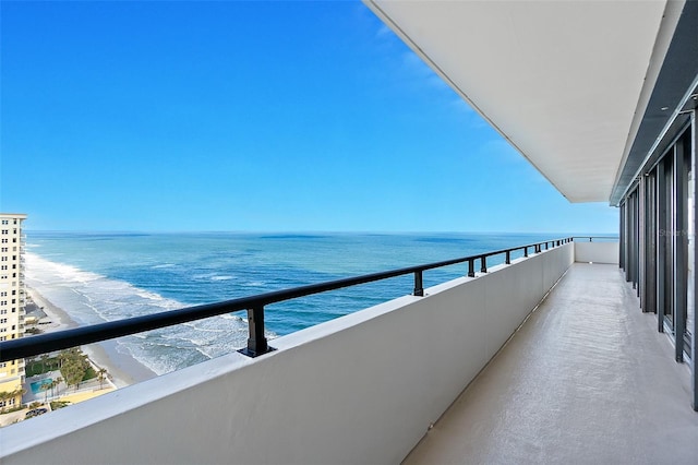 balcony featuring a beach view and a water view