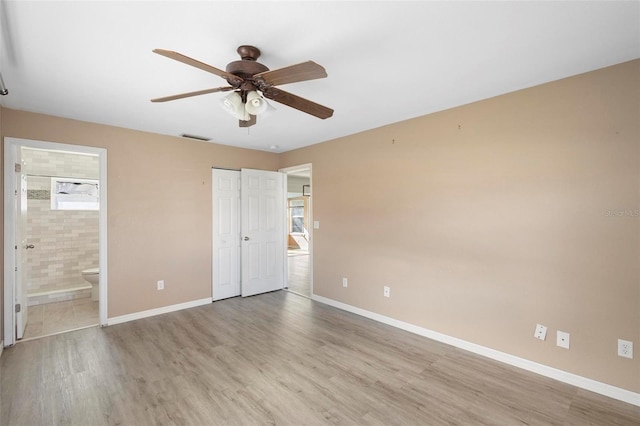 unfurnished bedroom with ceiling fan, light hardwood / wood-style floors, connected bathroom, and a closet