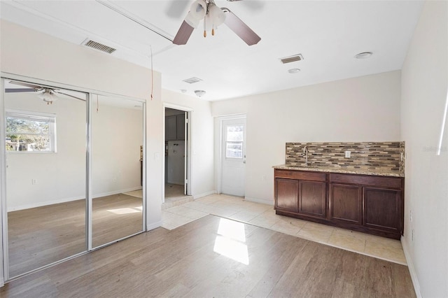 interior space featuring a wealth of natural light, tasteful backsplash, and hardwood / wood-style floors