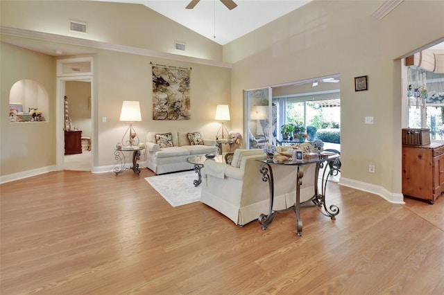 living room with ceiling fan, light wood-type flooring, and vaulted ceiling