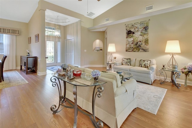 living room featuring a high ceiling, light hardwood / wood-style flooring, and ceiling fan