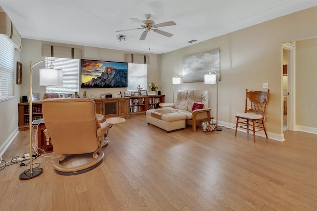 living room featuring light hardwood / wood-style floors and ceiling fan