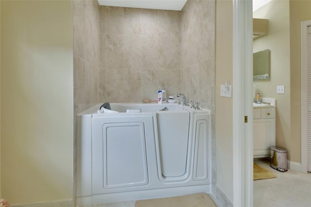 bathroom with tile patterned flooring, a bath, and washer / clothes dryer