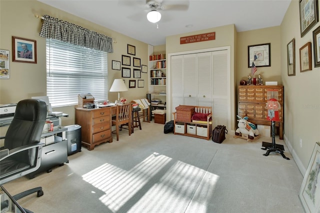 carpeted home office featuring ceiling fan