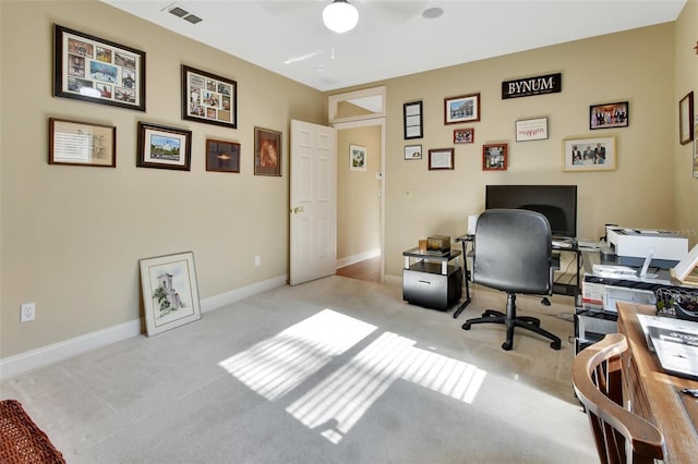 carpeted office space with ceiling fan