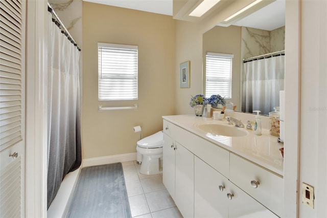 bathroom featuring tile patterned flooring, vanity, a healthy amount of sunlight, and toilet