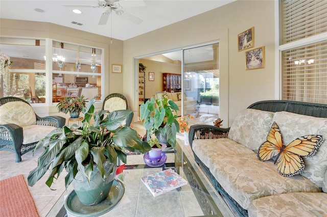 sunroom / solarium with ceiling fan with notable chandelier and a wealth of natural light