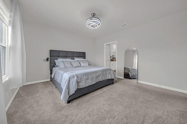 bedroom featuring multiple windows and light carpet